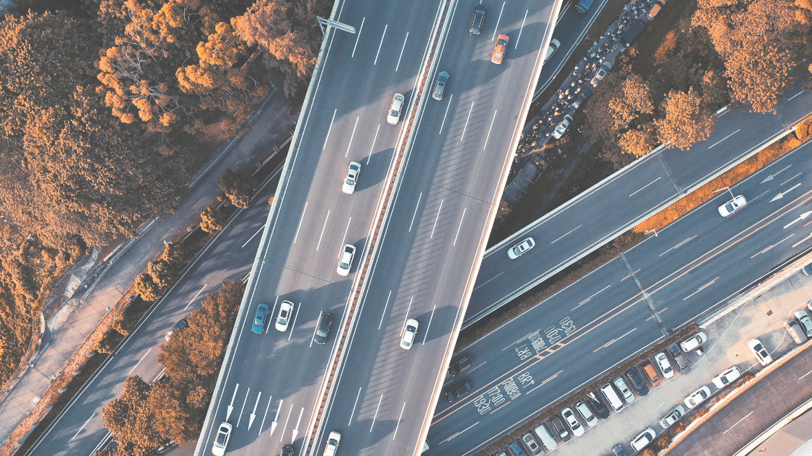 Vista dall'alto di un complesso svincolo autostradale con viadotti, sovrappassi e veicoli in transito, contesto d'uso del sistema Axatel Angel Bridge.